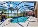 Stunning pool with a screened enclosure overlooking a beautiful lake and tropical landscaping at 13347 Golf Pointe Dr, Port Charlotte, FL 33953