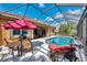 Relaxing screened-in pool area featuring a dining set and lounge chairs, perfect for enjoying sunny days at 13347 Golf Pointe Dr, Port Charlotte, FL 33953