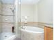 Bright bathroom with a tiled glass-enclosed shower and separate soaking tub at 1375 Beach Rd # 109, Englewood, FL 34223