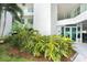 Condo entrance with lush tropical landscaping and covered parking at 1375 Beach Rd # 109, Englewood, FL 34223