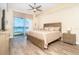 Bright main bedroom with wood-look floors and a slider to the balcony with water views at 1375 Beach Rd # 109, Englewood, FL 34223