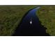 Aerial view of a sailboat navigating a tranquil river surrounded by lush, green landscapes at 13951 Allamanda Cir, Port Charlotte, FL 33981