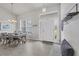 Bright dining area with a farmhouse table, stylish chairs, and a view of the front entrance at 13951 Allamanda Cir, Port Charlotte, FL 33981