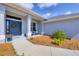 Close up of a home's front porch with blue chairs, potted plants, and a decorative wreath on the front door at 13951 Allamanda Cir, Port Charlotte, FL 33981