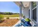 Relaxing porch with cozy blue chairs and lush landscaping, perfect for enjoying the outdoors at 13951 Allamanda Cir, Port Charlotte, FL 33981