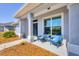 Inviting front porch with blue chairs, walkway, and a view of the well-maintained landscaping at 13951 Allamanda Cir, Port Charlotte, FL 33981