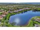 High aerial view showcases the community, a tranquil lake and the beautiful homes surrounded by lush landscaping at 14405 Silver Lakes Cir, Port Charlotte, FL 33953