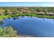 Aerial view of a lake reflecting the sky highlighting the home with surrounding landscape at 14405 Silver Lakes Cir, Port Charlotte, FL 33953