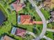 A beautiful aerial view of the home showing lush lawn, tile roof, mature landscaping and screened-in pool at 14405 Silver Lakes Cir, Port Charlotte, FL 33953