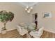 Dining room boasts glass table, seating for four, modern chandelier and adjacent access to the kitchen at 14405 Silver Lakes Cir, Port Charlotte, FL 33953