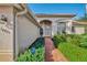 Inviting front entrance with brick walkway, colorful landscaping, and large windows at 14405 Silver Lakes Cir, Port Charlotte, FL 33953