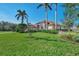 Manicured lawn with beautiful landscaping around this single Gathering home with a terracotta-colored tile roof at 14405 Silver Lakes Cir, Port Charlotte, FL 33953