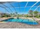 Sparkling swimming pool is surrounded by decorative concrete and screened in lanai, plus lake views at 14405 Silver Lakes Cir, Port Charlotte, FL 33953