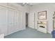 Bedroom featuring large closets, a ceiling fan, and neutral colored walls with blue carpet at 14429 Bridgeview Ln, Port Charlotte, FL 33953