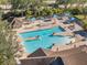 Aerial view of a community pool and spa surrounded by lounge chairs and sun umbrellas at 14429 Bridgeview Ln, Port Charlotte, FL 33953