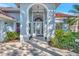 Close-up of front entrance showing arched doorway and glass front door with manicured landscaping at 14429 Bridgeview Ln, Port Charlotte, FL 33953