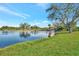 Picturesque lake with tree lined and grass covered shore at 14429 Bridgeview Ln, Port Charlotte, FL 33953