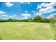 A manicured lawn bowling court with a green surface, benches, and manicured bushes at 14429 Bridgeview Ln, Port Charlotte, FL 33953