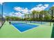 A view of the community pickleball courts with a green and blue surface, surrounded by a black chain link fence at 14429 Bridgeview Ln, Port Charlotte, FL 33953