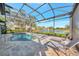 Beautiful pool and spa in screened in lanai with lounge chairs and view of the water at 14429 Bridgeview Ln, Port Charlotte, FL 33953