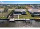 Aerial view of a waterfront home featuring a private dock and enclosed pool in the backyard at 15524 Ruston Cir, Port Charlotte, FL 33981