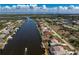 Stunning aerial view of waterfront home with a pool and private dock, showcasing canal access and neighborhood at 15524 Ruston Cir, Port Charlotte, FL 33981