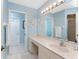 Bathroom with a long vanity, sink, mirror, and coastal-themed decor at 15524 Ruston Cir, Port Charlotte, FL 33981