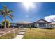 Exterior of well-maintained home, lush lawn, mature palm trees, and a screened lanai at 15524 Ruston Cir, Port Charlotte, FL 33981