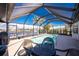 Screened pool with seating and tropical landscaping, overlooking a picturesque waterway at 15524 Ruston Cir, Port Charlotte, FL 33981