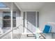 Entrance to the home through the screened porch, highlighting the gray front door and seating area at 1586 Overbrook Rd, Englewood, FL 34223