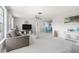 Bright living room featuring plush carpeting, contemporary furniture, and a view of the dining area at 1586 Overbrook Rd, Englewood, FL 34223