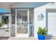 Close-up of the screened-in porch entrance featuring an entry door and white gravel landscaping at 1586 Overbrook Rd, Englewood, FL 34223