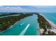 Picturesque aerial view of a turquoise waterway and beach with boaters enjoying a day out at 1591 Beach Rd # 403, Englewood, FL 34223