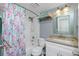 Bathroom with colorful shower curtain, white vanity, and framed mirror at 1591 Beach Rd # 403, Englewood, FL 34223