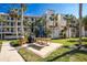 Exterior view of a multi-story condo with palm trees, balconies, and picnic area with grill at 1591 Beach Rd # 403, Englewood, FL 34223