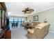 Spacious living room with furniture, water views, and fan at 1591 Beach Rd # 403, Englewood, FL 34223