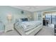 Serene main bedroom featuring a queen-size bed, blue accents, and a private balcony with water views at 1591 Beach Rd # 403, Englewood, FL 34223