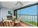 Balcony featuring a glass table and wicker chairs offering views of the waterway at 1651 Beach Rd # 301, Englewood, FL 34223