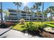 Three-story condo complex with multiple balconies, palm trees and beautiful landscaping at 1651 Beach Rd # 301, Englewood, FL 34223