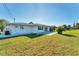 Lawn view of the backyard, the back of the house, sliding glass doors, and a patio at 1710 Loralin Dr, Englewood, FL 34223