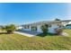 Wide backyard view featuring a white house and sliding glass doors onto a patio at 1710 Loralin Dr, Englewood, FL 34223