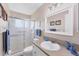 Bright bathroom featuring a glass shower, white vanity with a grey countertop, and decorative blue accents at 1710 Loralin Dr, Englewood, FL 34223