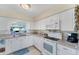 Clean kitchen with white cabinetry, modern appliances, and ample counter space for food preparation at 1710 Loralin Dr, Englewood, FL 34223