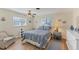 Light filled main bedroom with an accent chair and hardwood flooring at 1710 Loralin Dr, Englewood, FL 34223