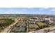 Panoramic aerial shot of the school, tennis courts, track, field, pond, and parking showcasing the recreational amenities at 17728 Silverspur Dr, Punta Gorda, FL 33982