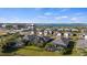 A scenic aerial view of a community showcasing houses with screened pools against the backdrop of a beautiful blue lake at 17728 Silverspur Dr, Punta Gorda, FL 33982