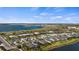 An aerial view shows a well-planned community of homes along a picturesque lake, under a beautiful sky at 17728 Silverspur Dr, Punta Gorda, FL 33982