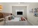 Neutral bedroom features a comfy bed with decorative pillows, a ceiling fan, and an adjacent dresser with a television at 17728 Silverspur Dr, Punta Gorda, FL 33982