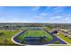 An elevated view shows a football field and track surrounded by a neighborhood and pond at 17728 Silverspur Dr, Punta Gorda, FL 33982