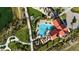 Aerial view of a community pool and clubhouse with lounge chairs and umbrellas for outdoor relaxation at 17728 Silverspur Dr, Punta Gorda, FL 33982